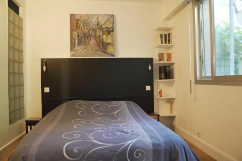 - une chambre avec un lit à tête noire dans l'établissement Appartement charmant à Paris 48 m² avec terrasse de 20 m², à Paris