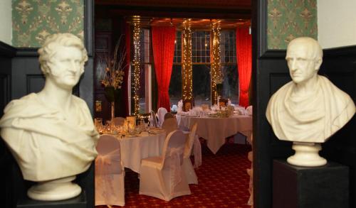 two busts of people in a room with a table at Bunchrew House Hotel in Inverness