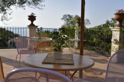 a table with a vase of flowers on a patio at Torre Galli-Dimora di Campagna in Gasponi