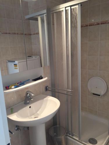 a bathroom with a sink and a shower and a sink at Sea-Zen De Panne in De Panne