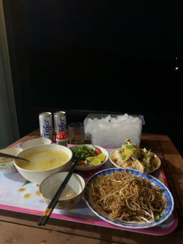 a table with plates of food and chopsticks on it at Gạo hạt dẻ homestay in Bao Loc