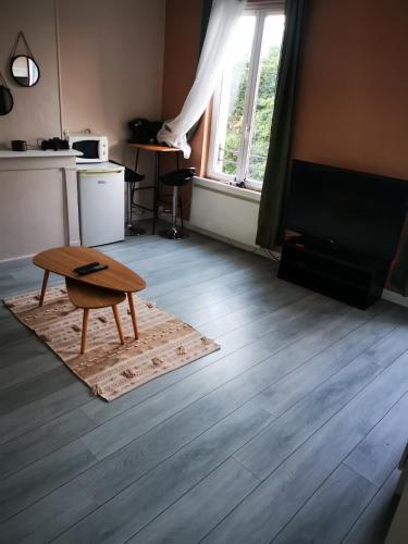 un salon avec une table et une télévision dans l'établissement La Fère, à La Fère