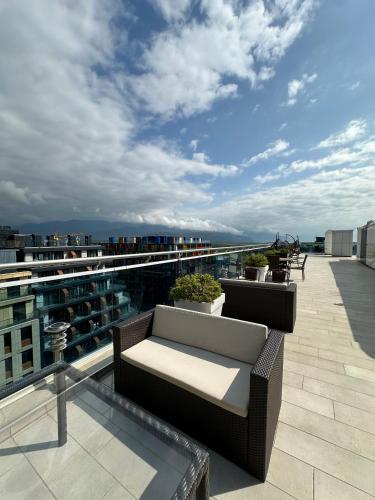 a balcony with a couch on top of a building at Business class studio with the Mountain View 115А in Batumi