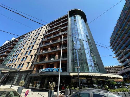 a tall glass building with a sign on it at Business class studio with the Mountain View 115А in Batumi