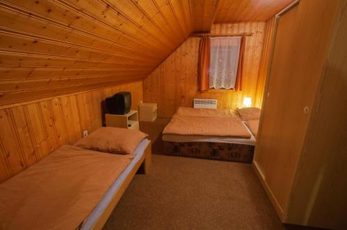 mały pokój z 2 łóżkami i telewizorem w obiekcie Chalupa Pohodička w mieście Studenec