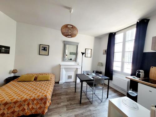 une chambre avec un lit, une table et un bureau dans l'établissement Appartement lumineux hypercentre proche Marché, à La Rochelle