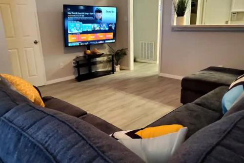 a living room with a couch and a flat screen tv at Gorgeous House & Loft Near Downtown in San Antonio