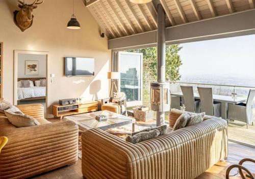 a living room with a couch and a table at Cottage In The Wood in Great Malvern