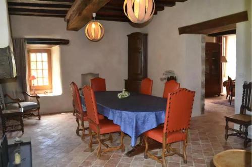 une salle à manger avec une table bleue et des chaises orange dans l'établissement Gîtes du domaine des Vaulx, à La Baconnière