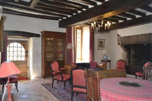 un salon avec des chaises rouges et une cheminée dans l'établissement Gîtes du domaine des Vaulx, à La Baconnière