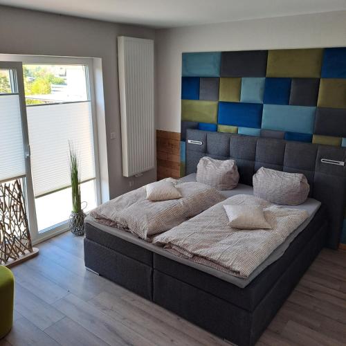 a bedroom with a large bed with a colorful headboard at Fewo Verena mit 2 Schlafzimmern in Diemelsee