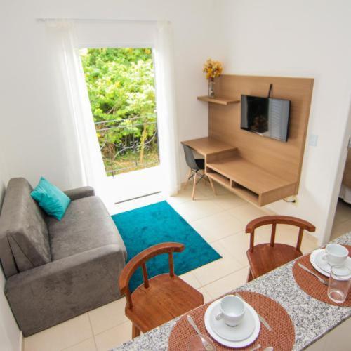 ein Wohnzimmer mit einer Couch und einem Tisch und Stühlen in der Unterkunft Apart Sol Nascente in Itatiaia