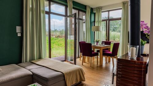a living room with a couch and a table with chairs at VacationClub - Osada Śnieżka Apartament 7 in Łomnica