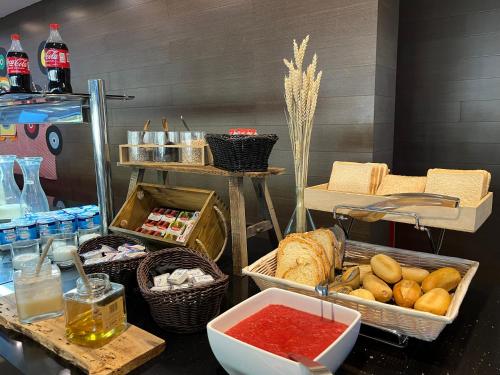 a table with baskets of bread and other foods at Wuau! Hotel Galanthus & Spa in Soldeu