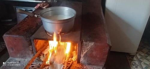 a pot on top of a stove with a fire at Sitio Alecrim Gastronomia e Hospedaria in Alagoa