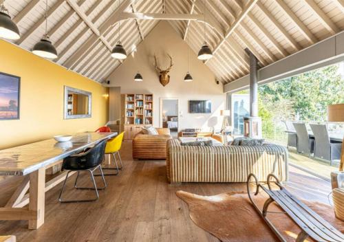 a living room with a table and a couch at Cottage In The Wood in Great Malvern