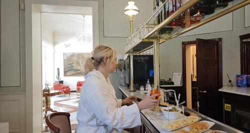 a woman standing in a kitchen preparing food at Grand Hotel Terme in Riolo Terme