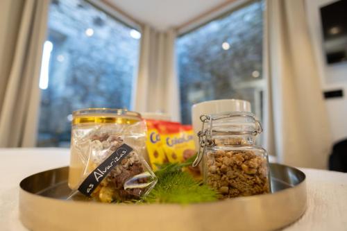 a metal bowl filled with jars of food on a table at as Alvarizas in Moraña