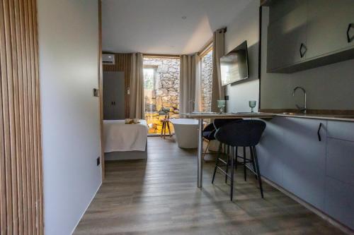 a kitchen with a counter and a table and chairs at as Alvarizas in Moraña