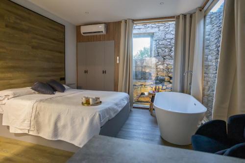 a bedroom with a tub and a bed and a window at as Alvarizas in Moraña