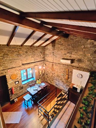 an overhead view of a room with a table and a stone wall at Azoka by the River- Proença-a-Nova in Maljoga de Proença