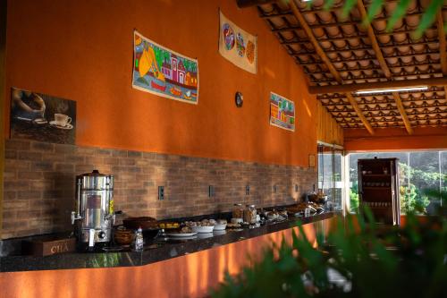 eine Küche mit orangefarbenen Wänden und einer Theke mit Lebensmitteln in der Unterkunft Canyons Camping Capitolio in Capitólio