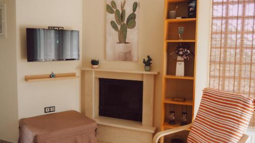ein Wohnzimmer mit einem TV und einem Kamin in der Unterkunft Summer house in Halkidiki in Paralia Dionisiou