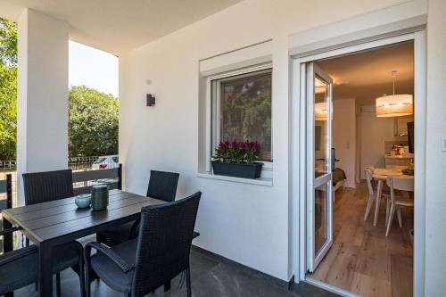 a dining room with a table and chairs and a window at Balatonic Lime apartmanház in Siófok