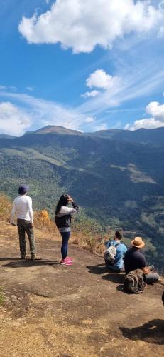 a group of people sitting on the side of a mountain at Sitio Alecrim Gastronomia e Hospedaria in Alagoa