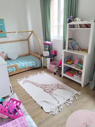 une chambre d'enfant avec un berceau et un tapis girafe dans l'établissement Cosy flat in Beauvais city center, à Beauvais