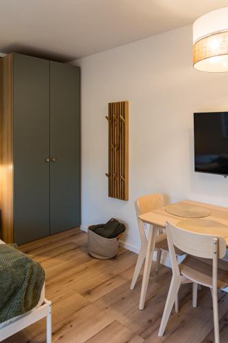 a dining room with a table and a tv at Balatonic Lime apartmanház in Siófok