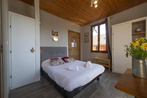 une chambre avec un lit avec des draps blancs et des oreillers dans l'établissement PINOT GRIS - Charmant studio au cœur du vignoble - parking gratuit, à Riquewihr