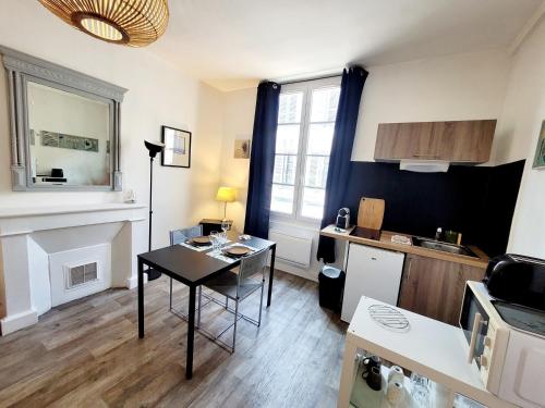un salon avec une table et une cuisine dans l'établissement Appartement lumineux hypercentre proche Marché, à La Rochelle