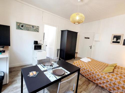 Cette petite chambre comprend un lit et une table. dans l'établissement Appartement lumineux hypercentre proche Marché, à La Rochelle