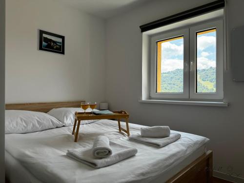 a room with a bed with a table and a window at Małe Pieniny in Szczawnica
