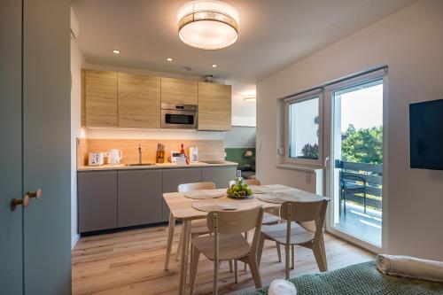 a kitchen and dining room with a table and chairs at Balatonic Lime apartmanház in Siófok