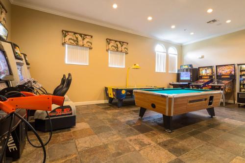 a room with a pool table and arcade games at Walkin' on Sunshine - 5 bed pool home in Terra Verde Resort near Disney in Kissimmee