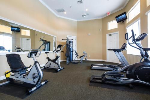 a gym with several treadmills and exercise bikes at Walkin' on Sunshine - 5 bed pool home in Terra Verde Resort near Disney in Kissimmee