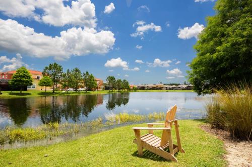 a wooden bench sitting in front of a lake at Walkin' on Sunshine - 5 bed pool home in Terra Verde Resort near Disney in Kissimmee