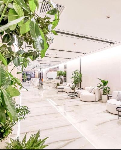 a lobby with white furniture and plants at Coastline Luxury Apart Hotel in Golem
