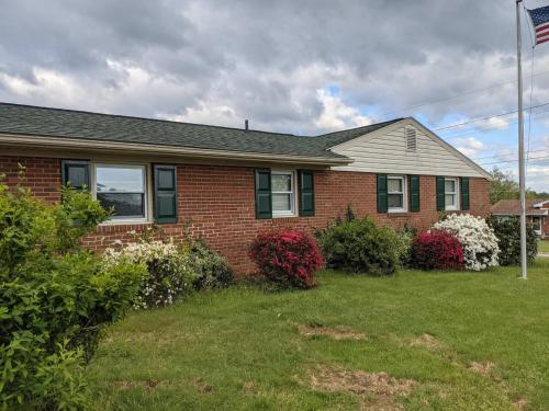 a brick house with a flag in the yard at Spacious 3B2B Minutes to Skyline in Waynesboro