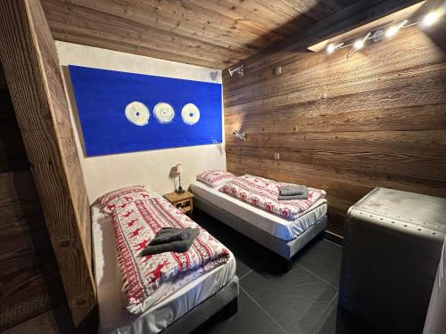 deux lits jumeaux dans une chambre aux murs en bois dans l'établissement Wintergarten2, à Valmorel