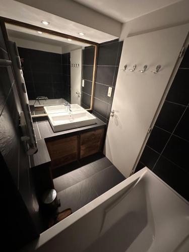 une salle de bain avec un lavabo et un grand miroir dans l'établissement Wintergarten2, à Valmorel