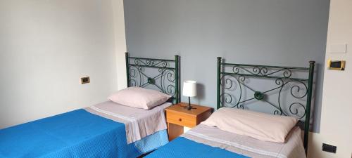 a bedroom with two beds and a table with a lamp at SeaSun House in Capo dʼOrlando