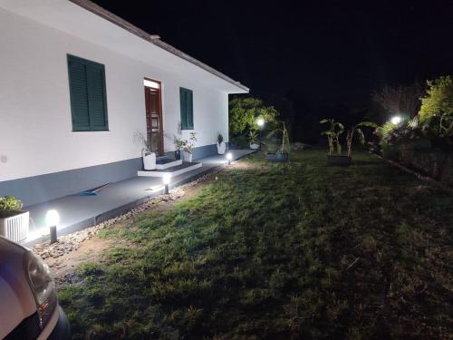 a house with lights in the yard at night at SeaSun House in Capo dʼOrlando