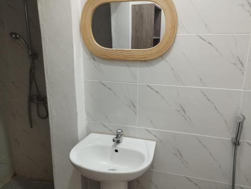 a bathroom with a sink and a mirror on the wall at Residence jaune in Dzaoudzi