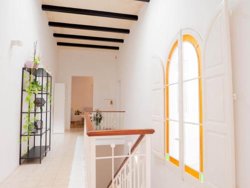 een hal met witte muren en een trap met ramen bij Villa Luciano - Rooftop Jacuzzi, BBQ, Billiards & Steps from Sea in Sliema