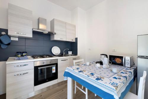 a small kitchen with a table with a blue wall at Il Borgo Incantato con garage in Finale Ligure