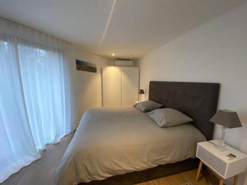 une chambre avec un grand lit et une grande fenêtre dans l'établissement Appartement T2 Pyla-sur-mer, à La Teste-de-Buch