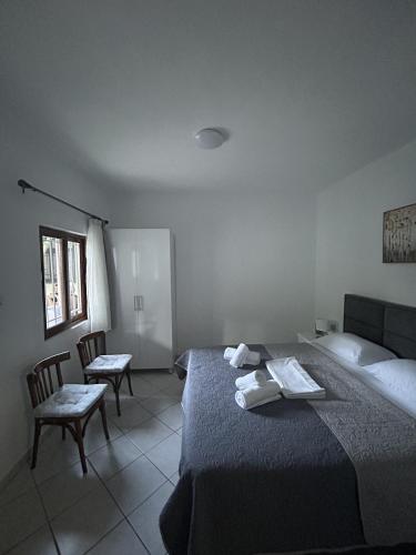 a bedroom with a bed and two chairs and a window at Annas home in Borsh